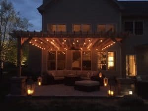 Freestanding Big Kahuna Pergola outside of house in the evening with lights