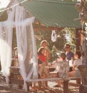 People sitting under a pergola with a mesh net